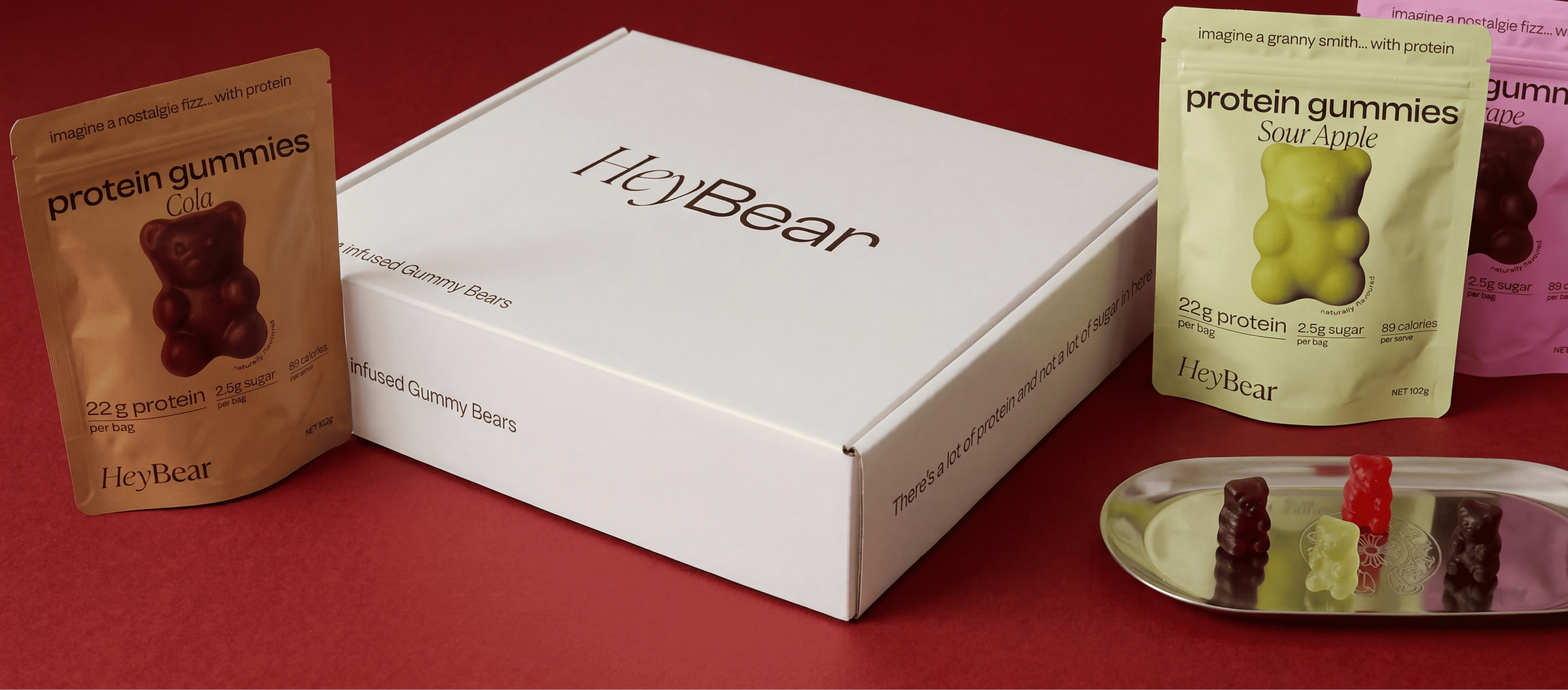 HeyBear protein gummies packaging on a red background